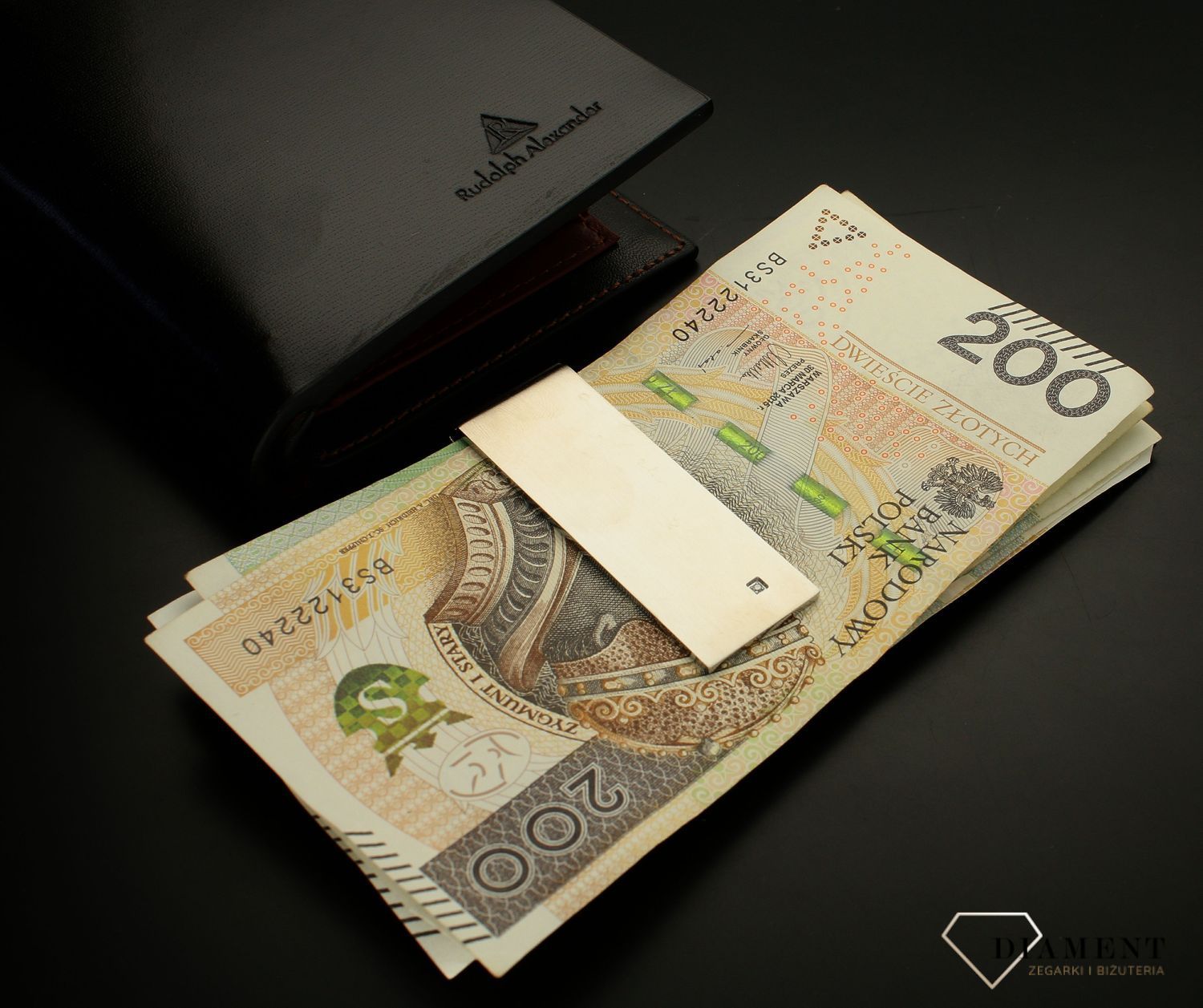 Klips do banknotów Nomination z Diamentem 028310 008. Oryginalny klips do banknotów wykonany ze stali szlachetnej pokryty metodą PVD w kolorze srebrnym. Elegancji dodaje jasny diament na najbardziej widocznym miejscu.webp